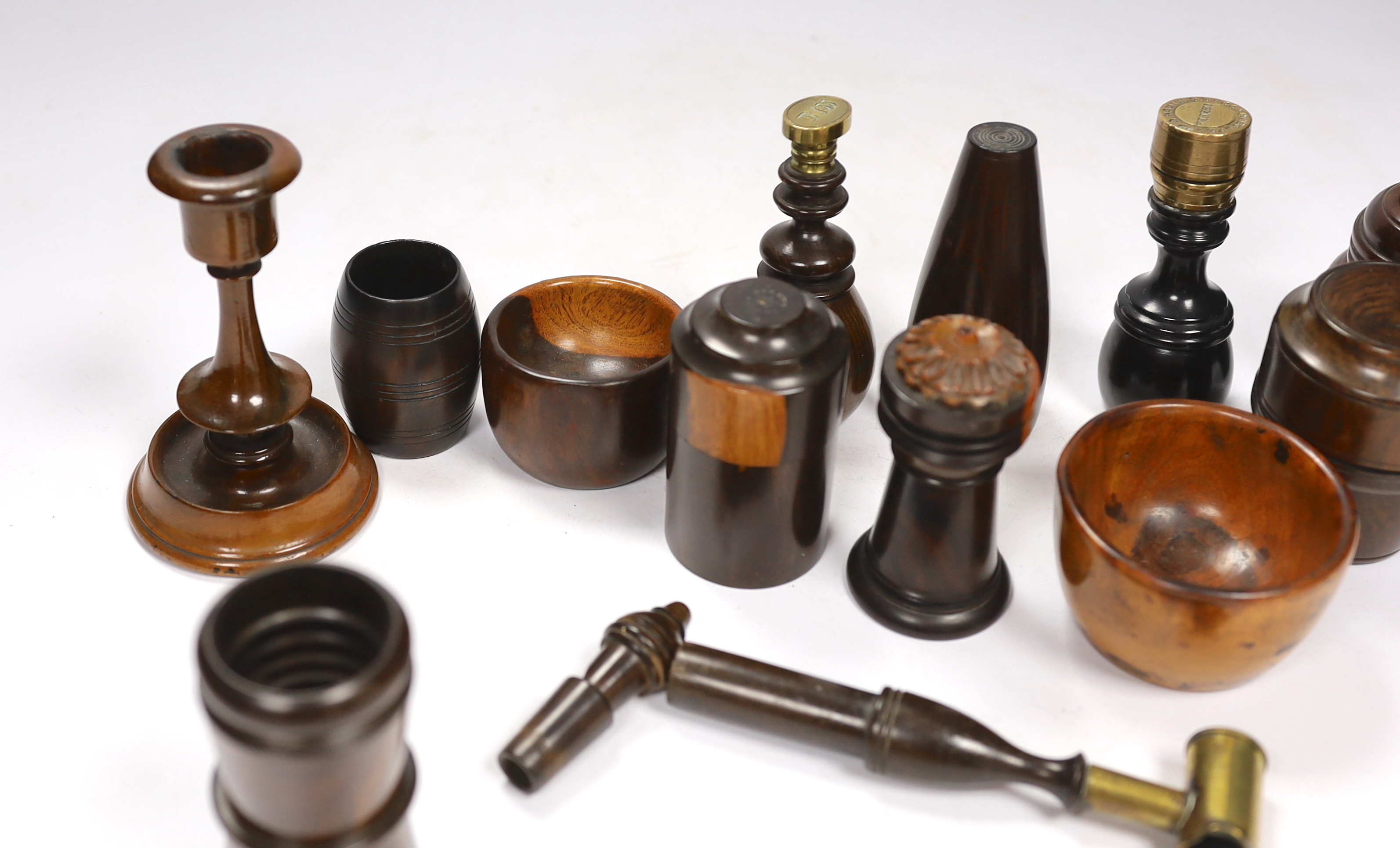 A collection of 19th/20th century lignum vitae vessels and desk items, to include a pepper pot, salt pot, two desk seals, a whistle, a candlestick etc.